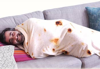 Model wrapped in the tortilla blanket on a couch