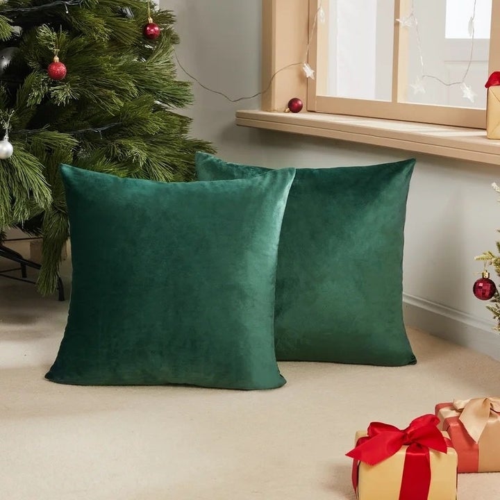 A set of green pillows on a floor with gifts