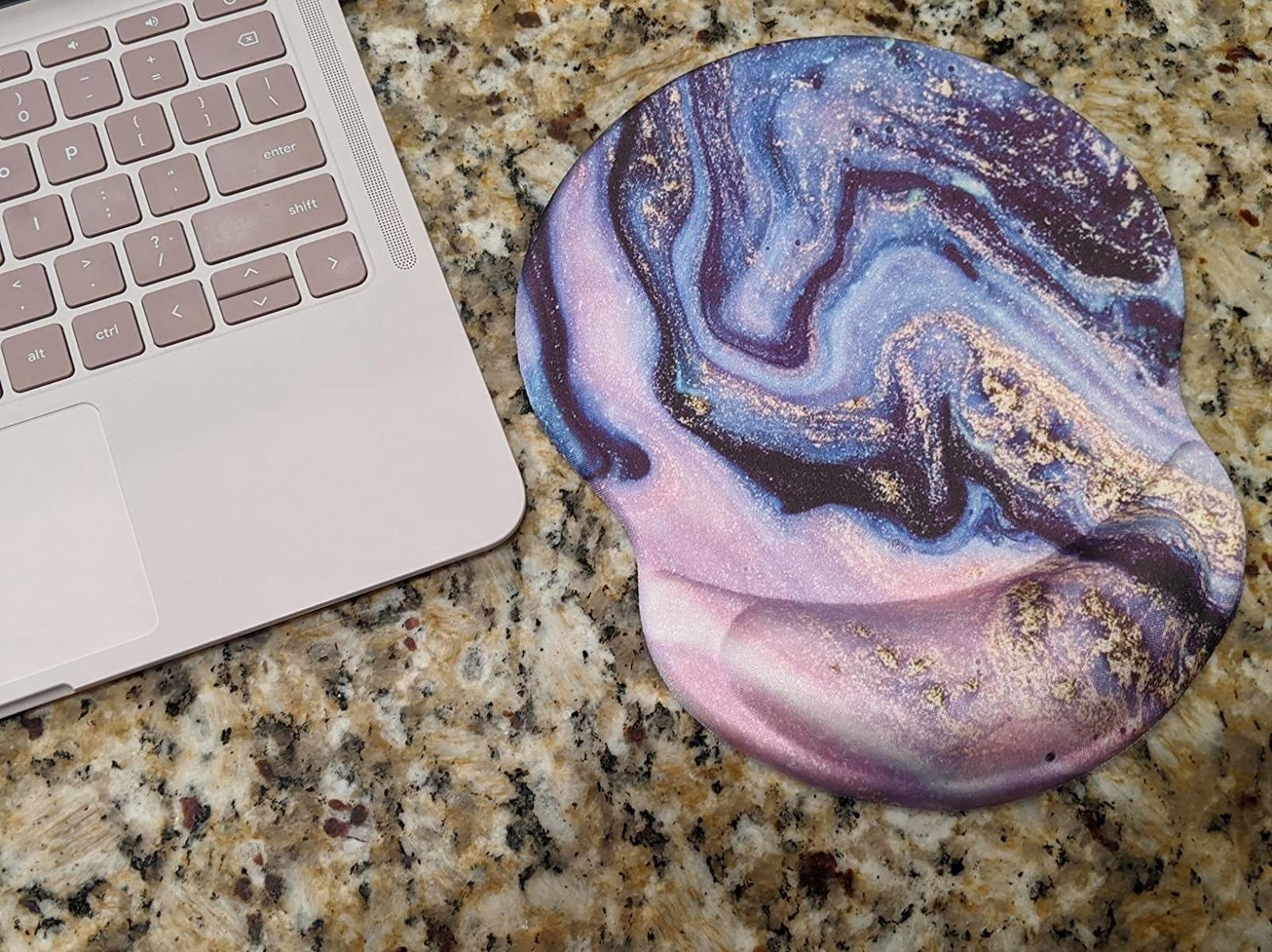 the mousepad in a metallic marbled blue, pink and purple design