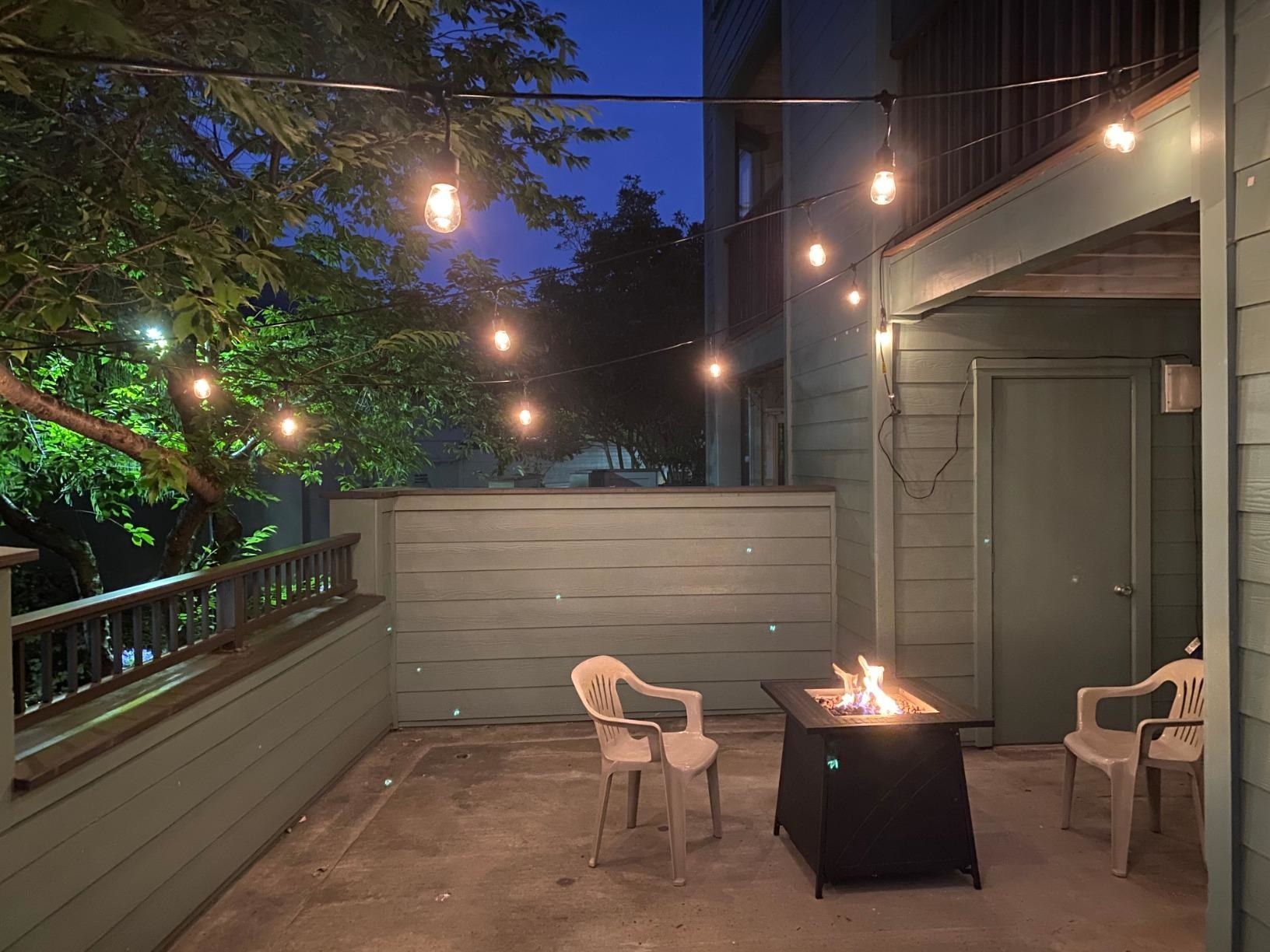 reviewer image of the lights hanging above a patio with a chair and firepit