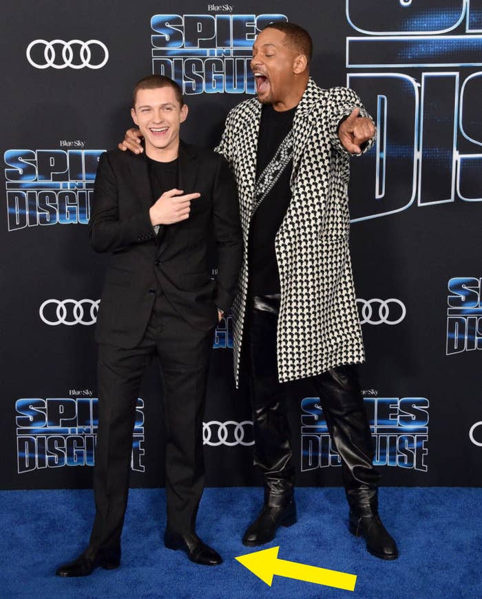 Tom standing slightly in front of Will Smith at the premiere of their film onward