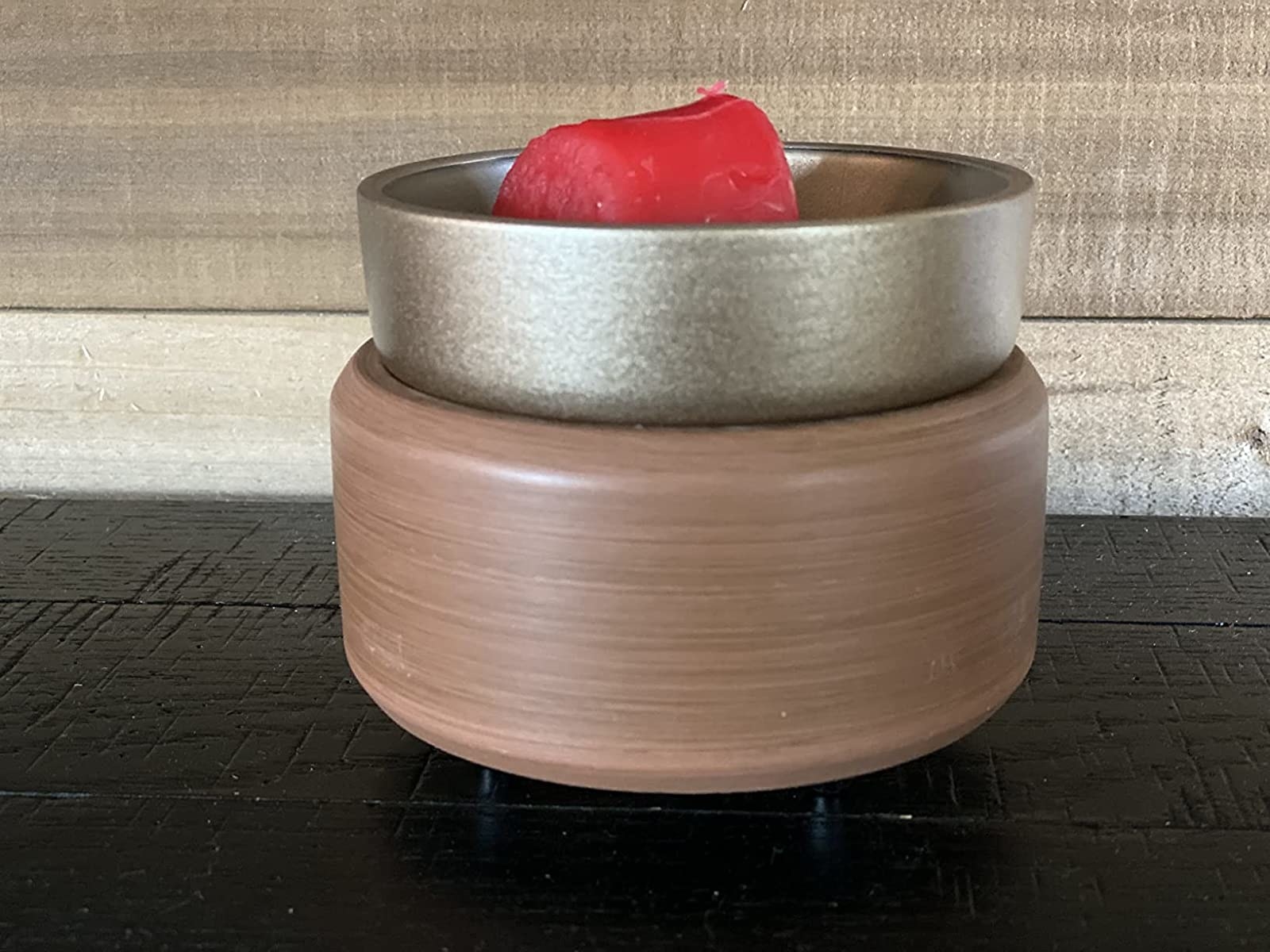 the wax warmer with a brown base and metal top with red wax in the top