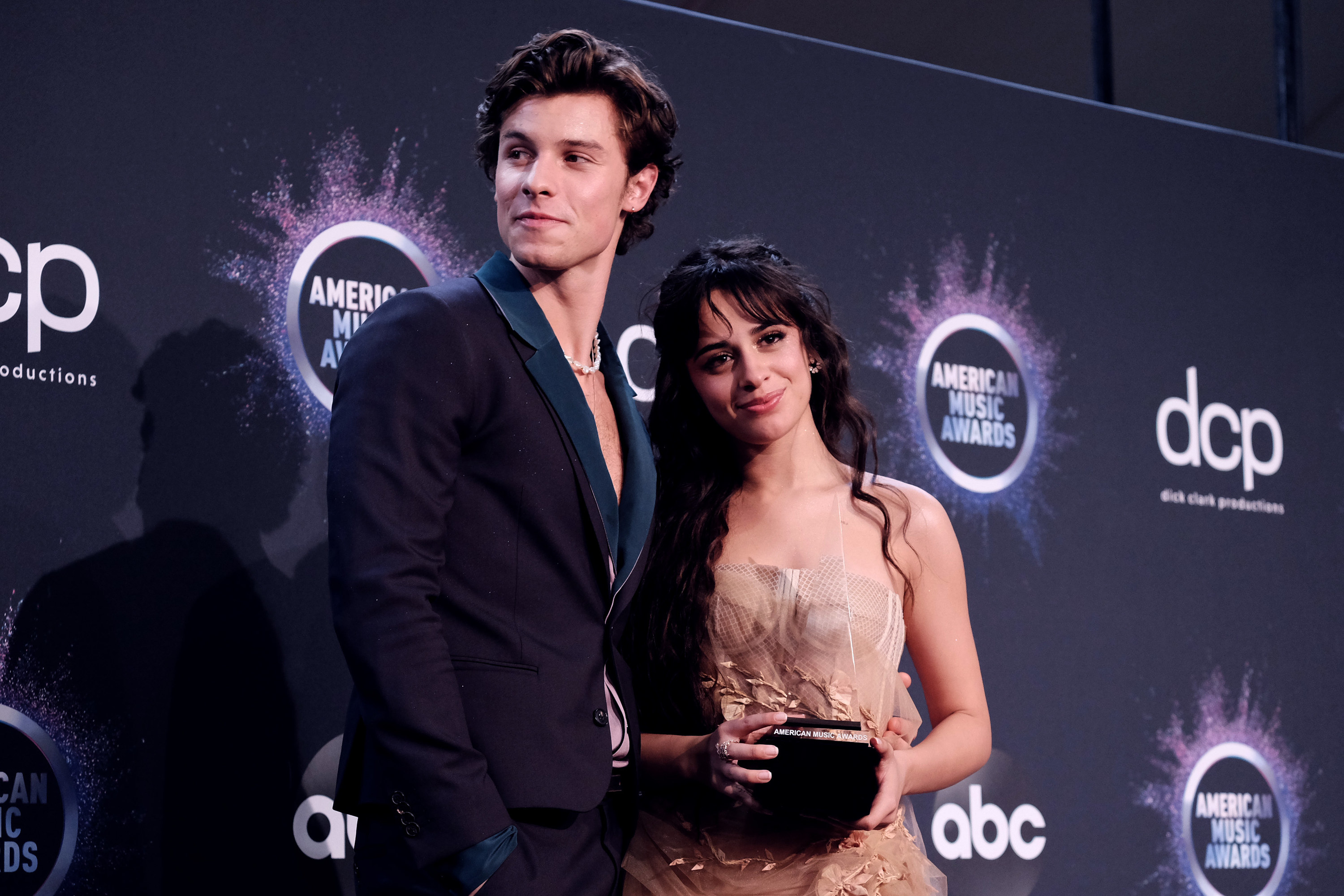 Mendes and Cabello pose for a photo as Cabello holds an award