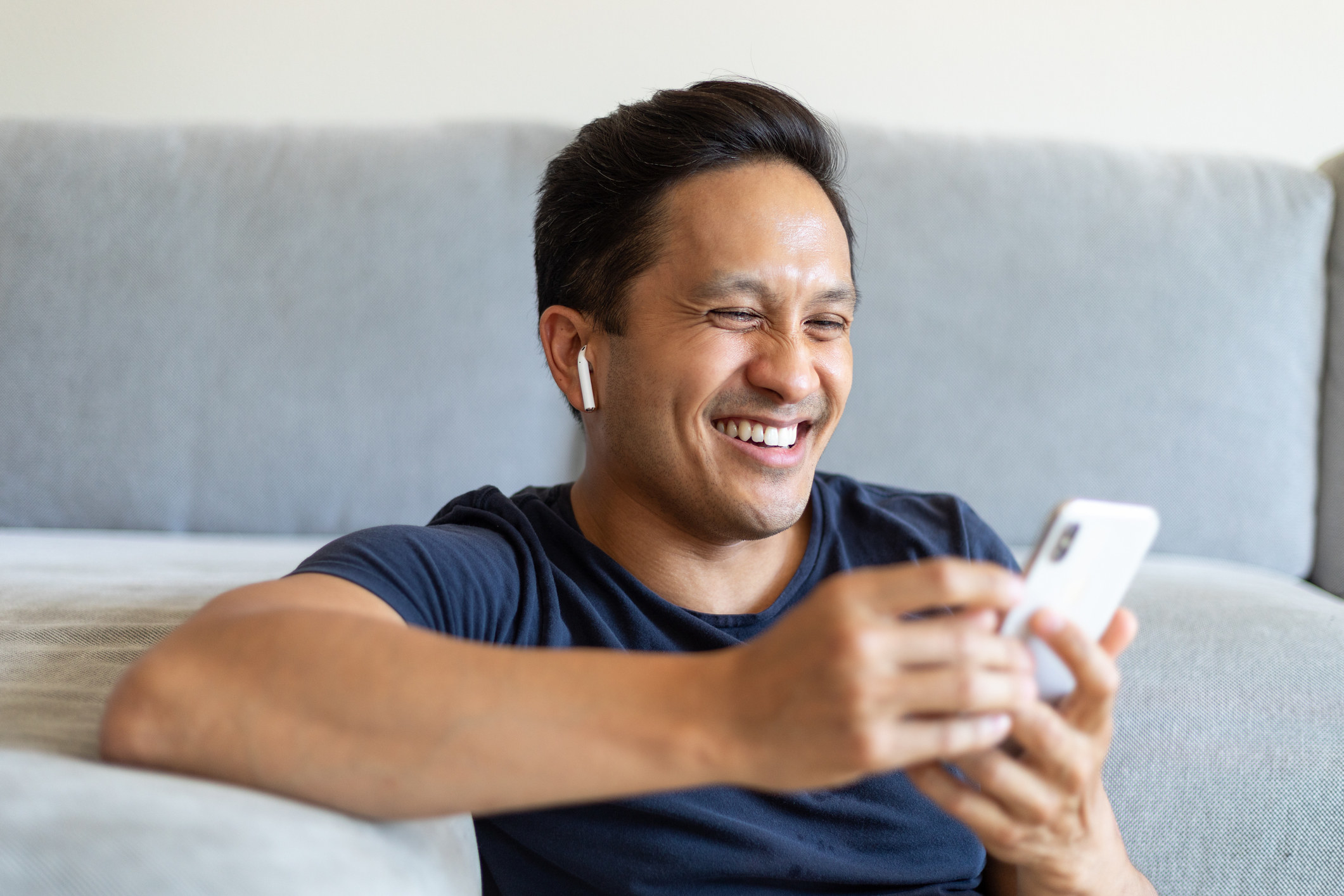 A man laughing while using his phone