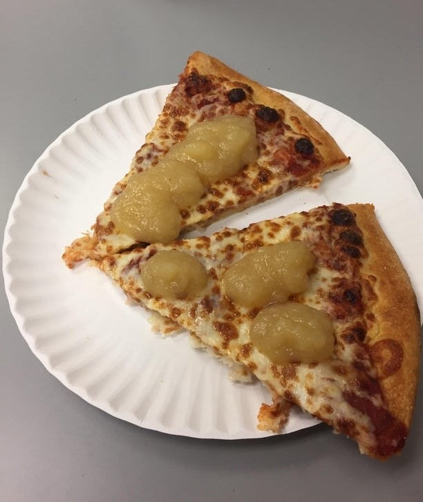 Two slices of pizza with applesauce on top.