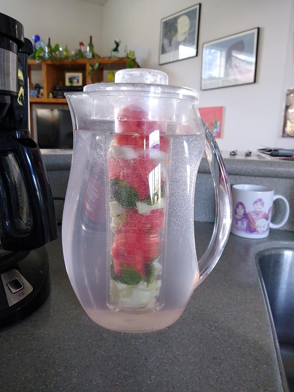 the pitcher filled with water and fruits in the center