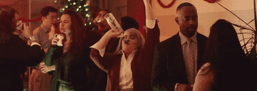 GIF woman drinking in middle of party crowd
