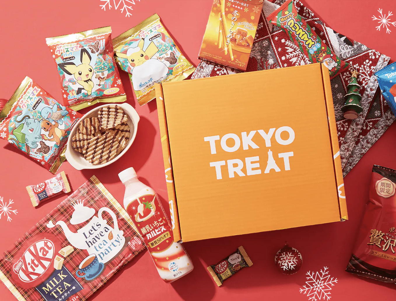 A Tokyo Treat subscription box surrounded by a wide variety of holiday Japanese snacks