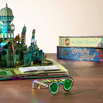emerald city pop up page next to green paper glasses