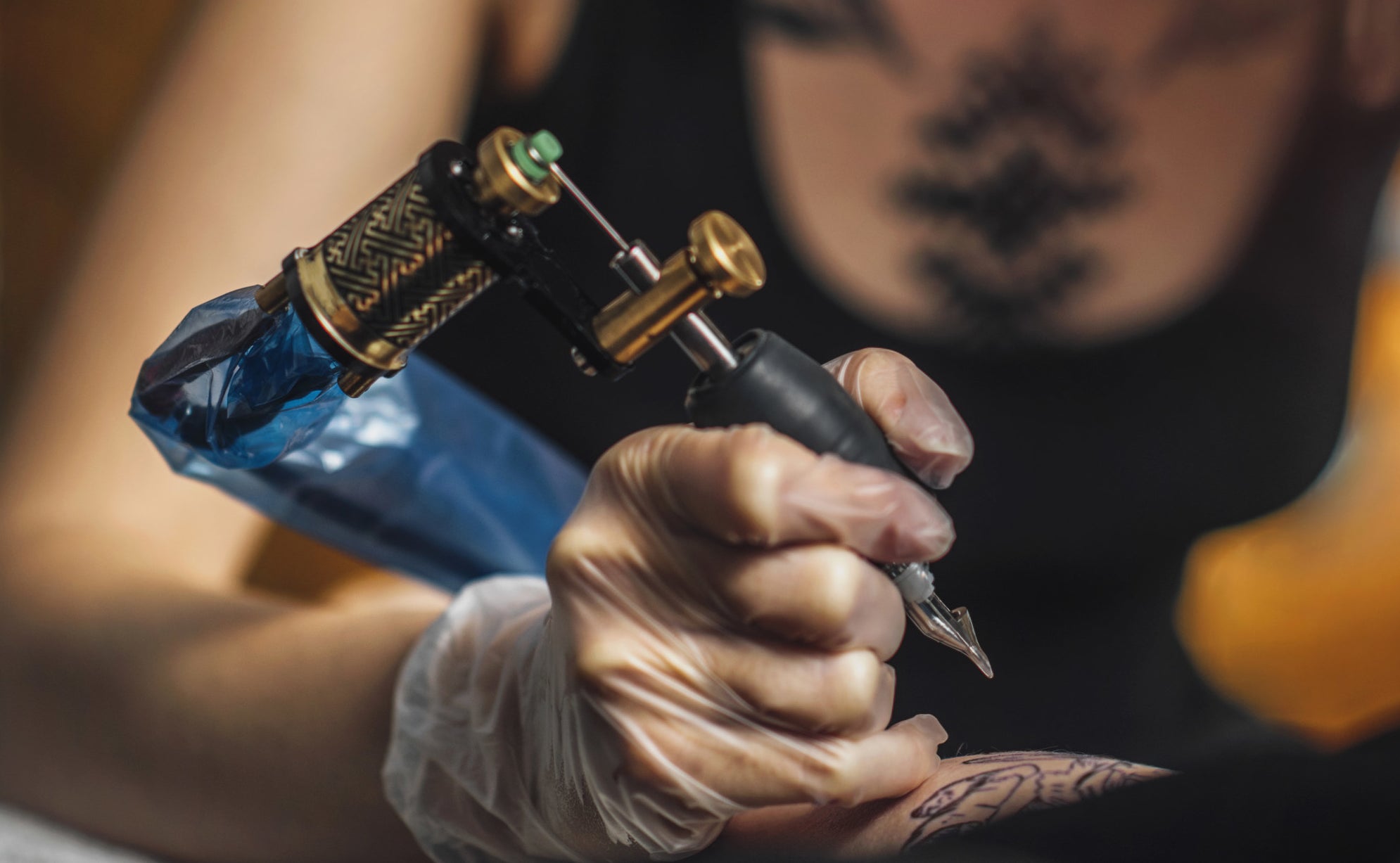 woman tattoo artist giving a tattoo