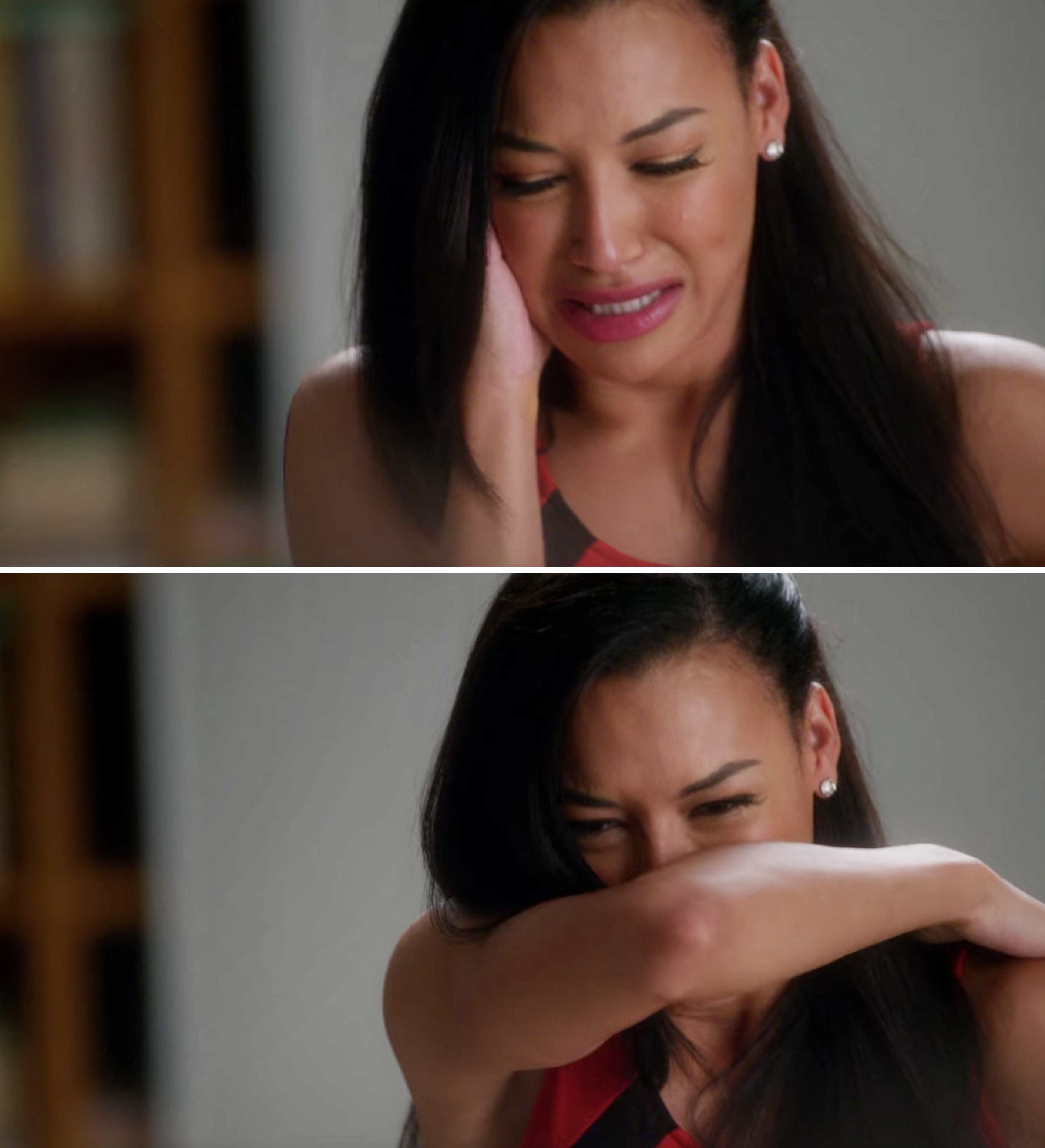 Naya crying and covering her mouth with the crook of her arm
