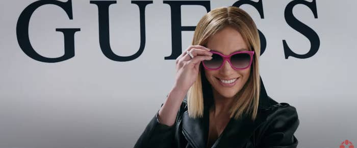 Kat smiles as she adjusts her large Guess sunglasses