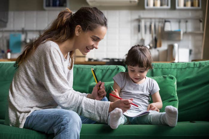 A young woman coloring with a kid