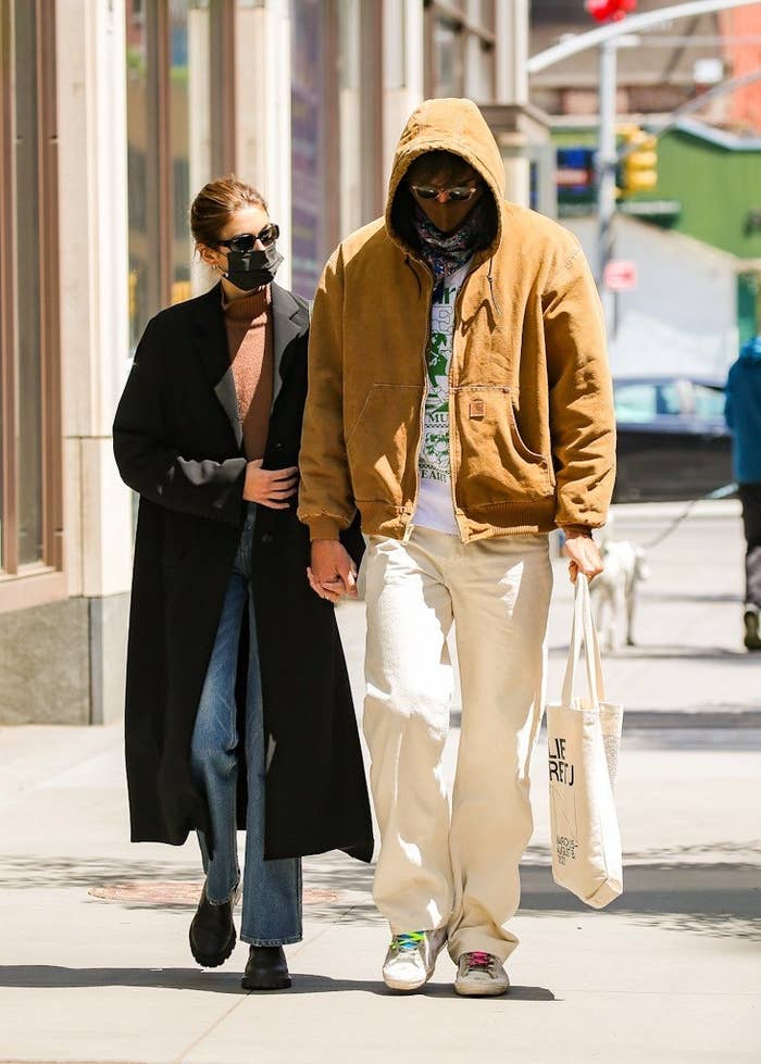 Gerber and Elordi walk down the street while wearing masks