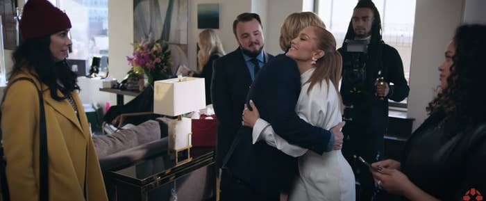 J Lo hugging someone in a room full of people