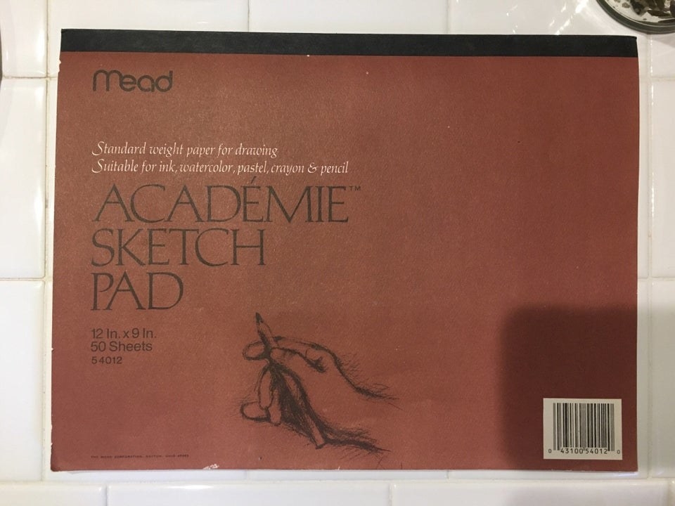 Sketch pad featuring a sketch of a hand holding a pencil on the cover