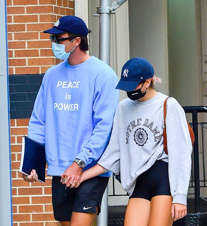 Gerber and Elordi walk outside while holding hands and wearing masks