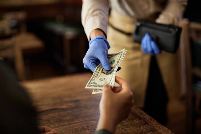 A customer handing cash to a waiter