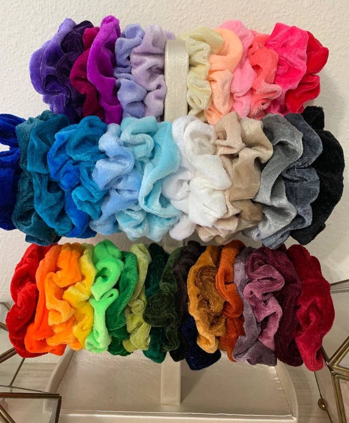 the scrunchies in various different colors displayed on a stand