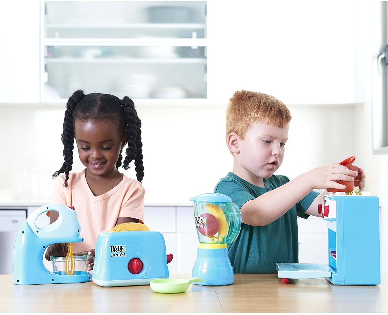two children playing with all the kitchen toys