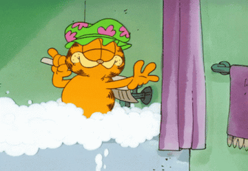 Garfield the cat scrubbing himself and taking a luxurious bubble bath
