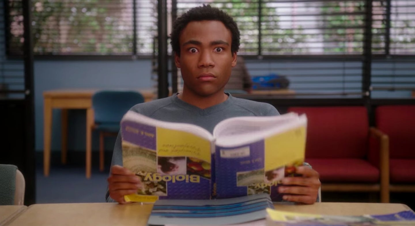 Troy holding a biology textbook upside down in &quot;Community&quot;