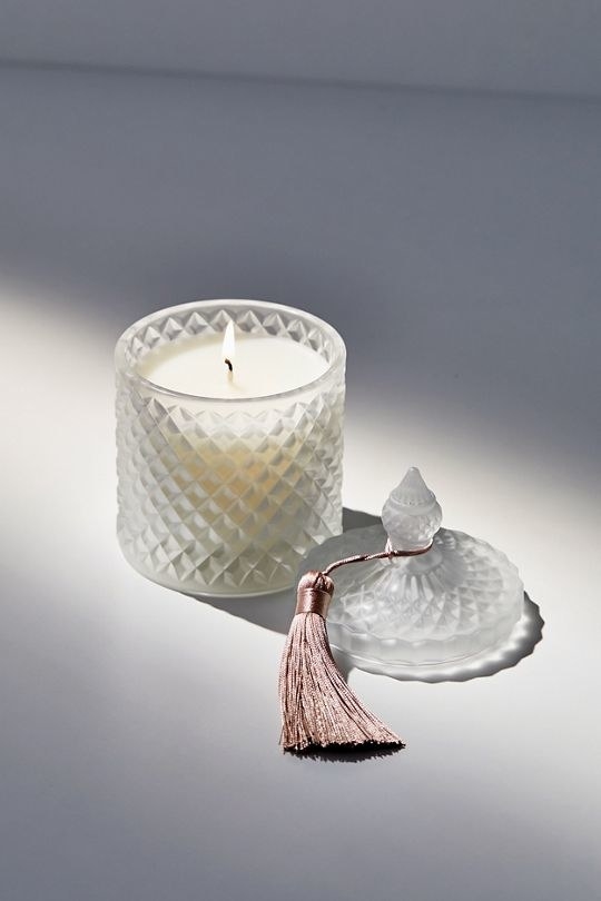 white glass candle with lid next to it