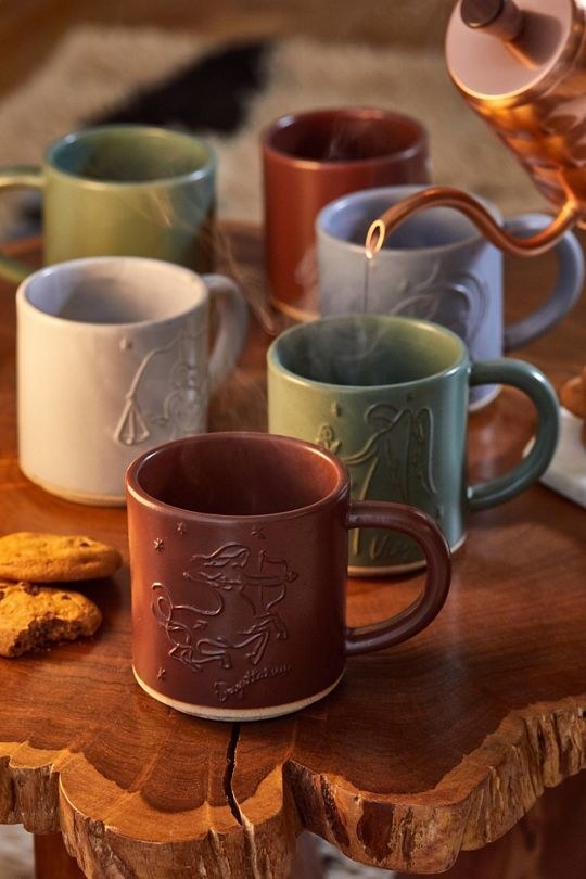 different color mugs with zodiac signs etched on them