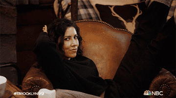 A character from Brooklyn 99 lounging on an armchair