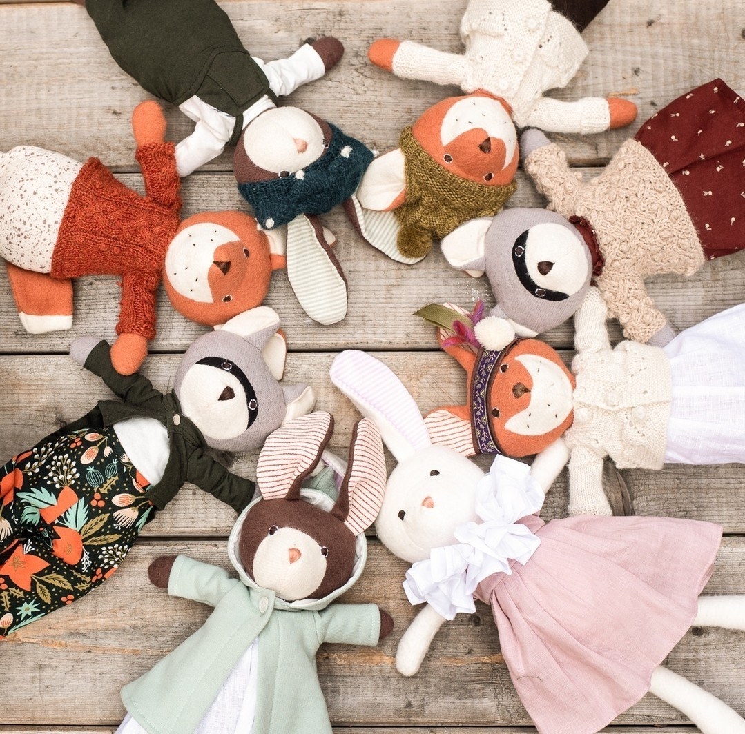 an array of stuffed animals in clothing in a circle