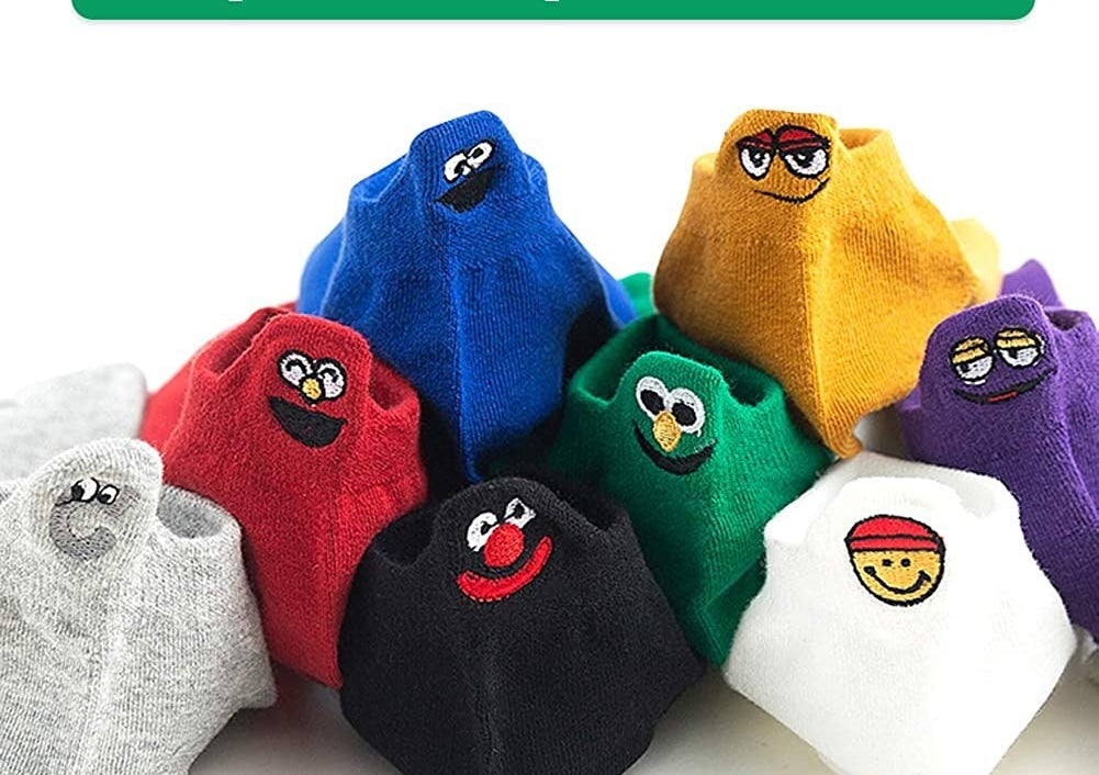 The variety of socks stacked on top of one another, each one stitched with a funny face on the back