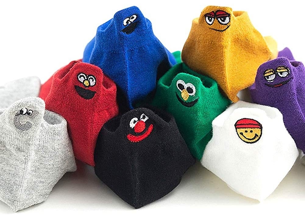 The variety of socks stacked on top of one another, each one stitched with a funny face on the back