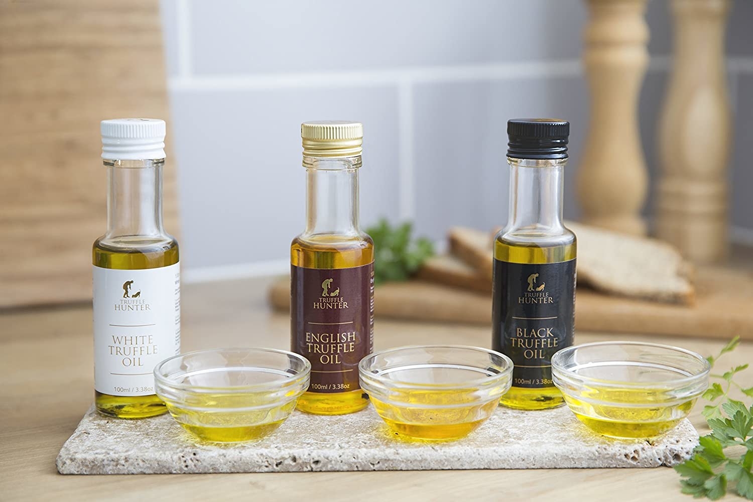 a set of three different truffle oils on a stone slab