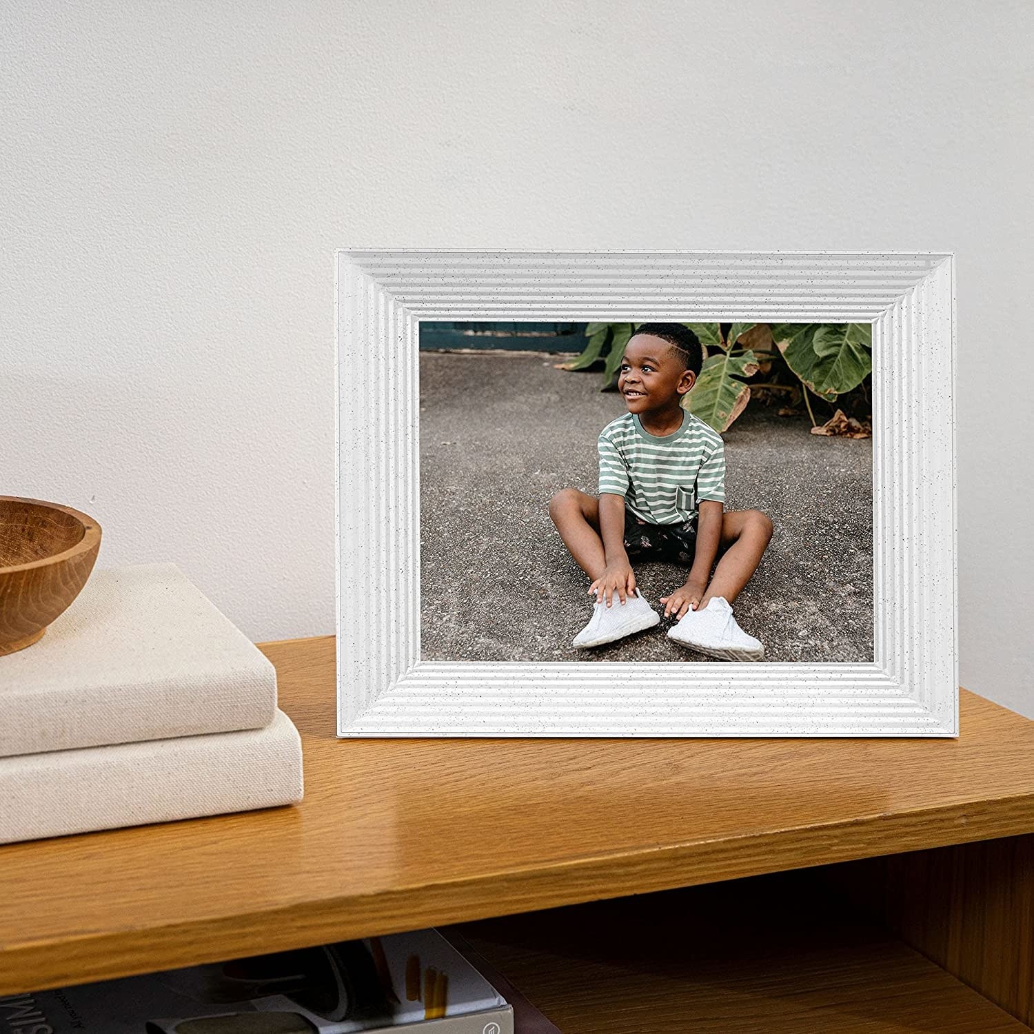 a photo of a child in the digital picture frame in the color white