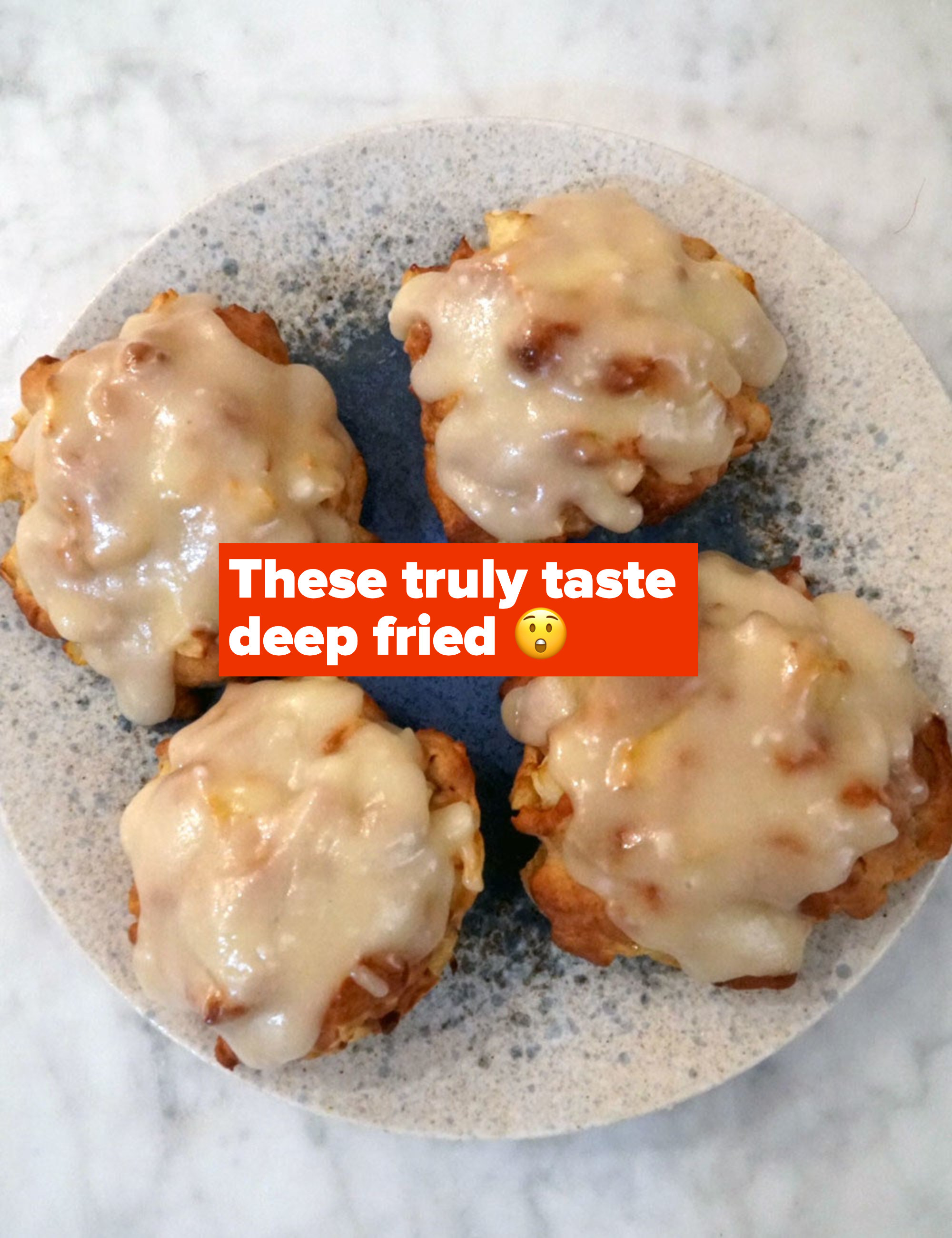 Apple fritters with icing on top.