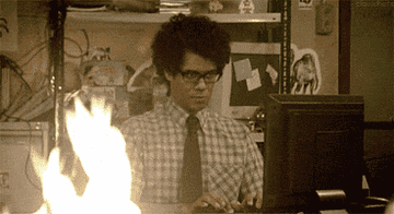 Moss typing at his computer behind a fire in &quot;The It Crowd&quot;