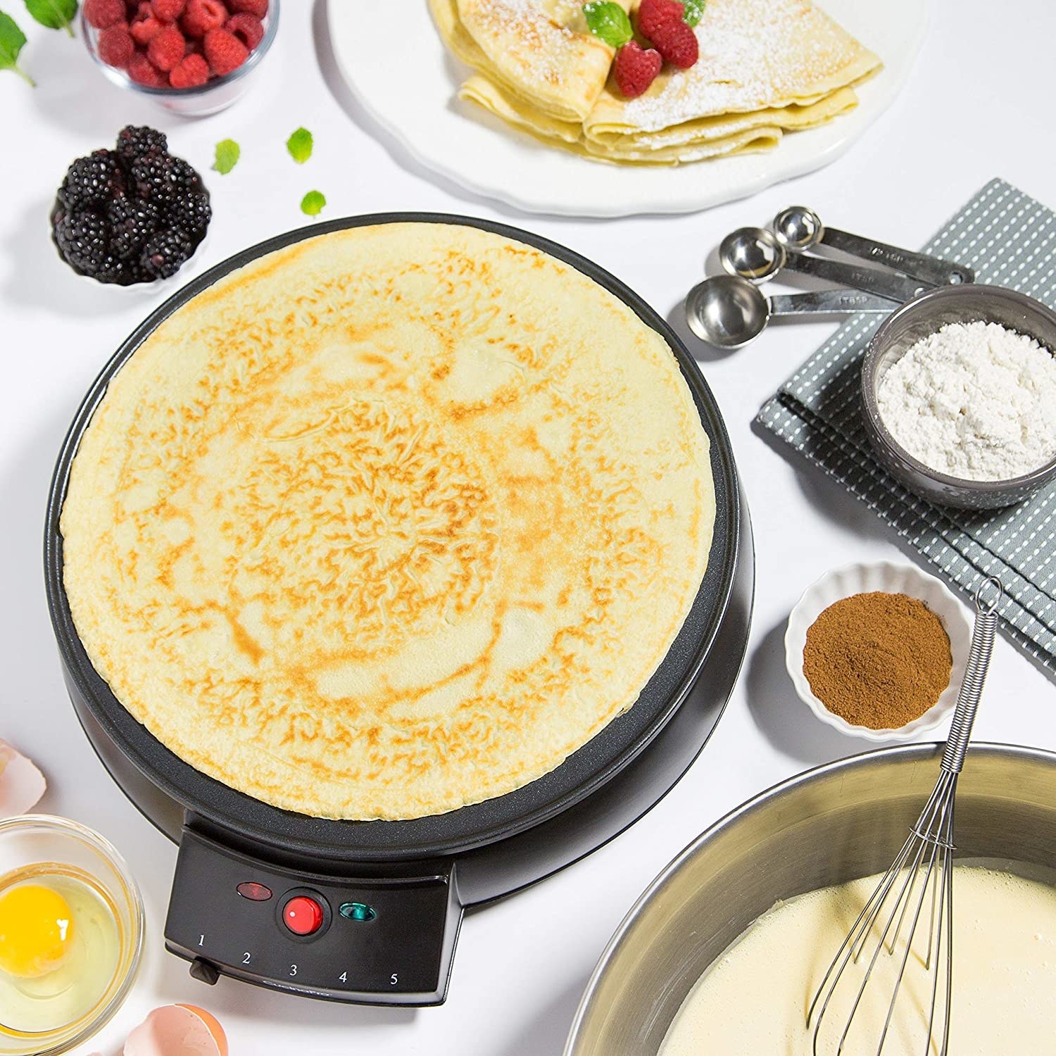a flatlay of someone making a crepe on the flat-top crepe maker