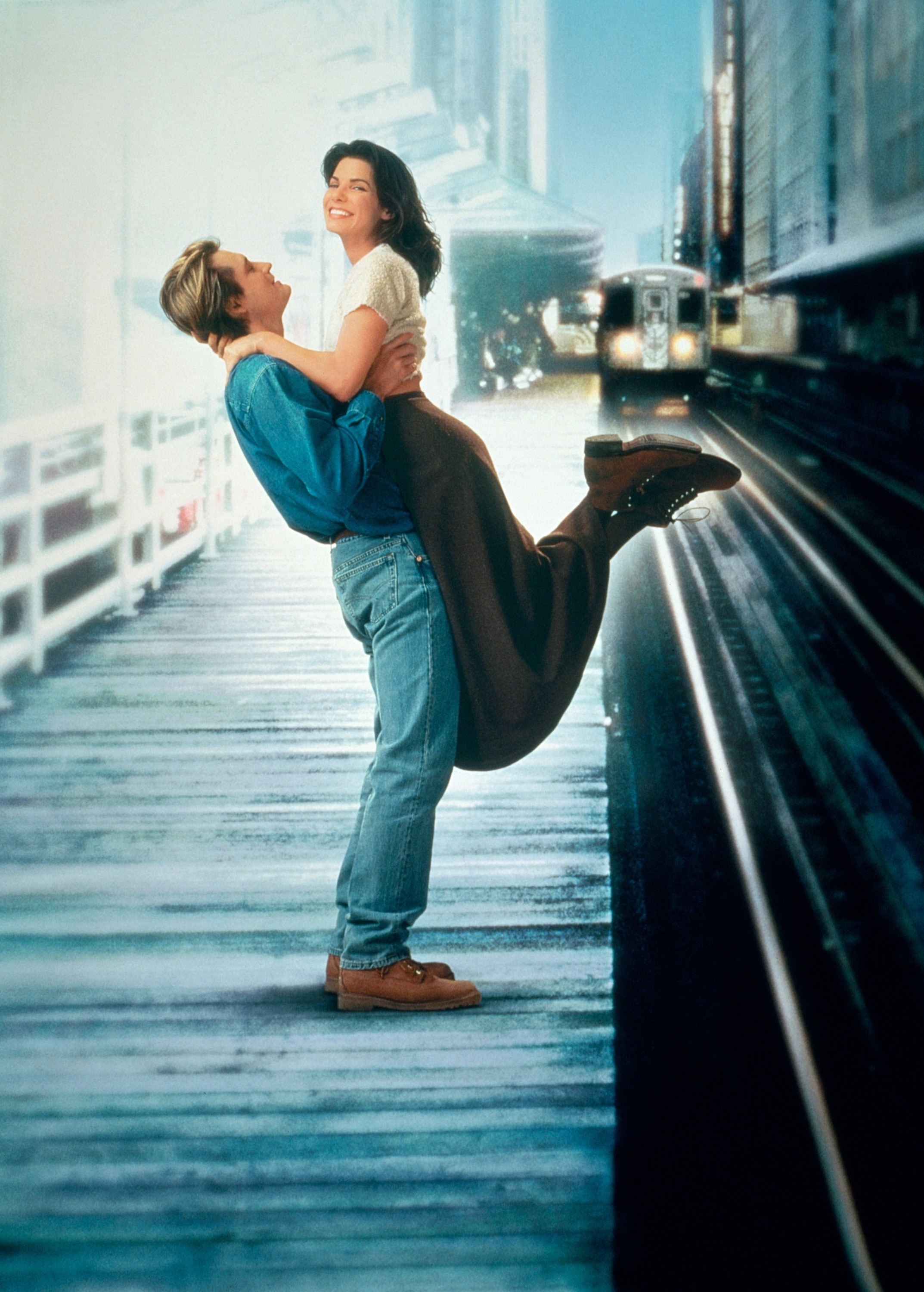 A man lifts a woman on the platform of a subway station