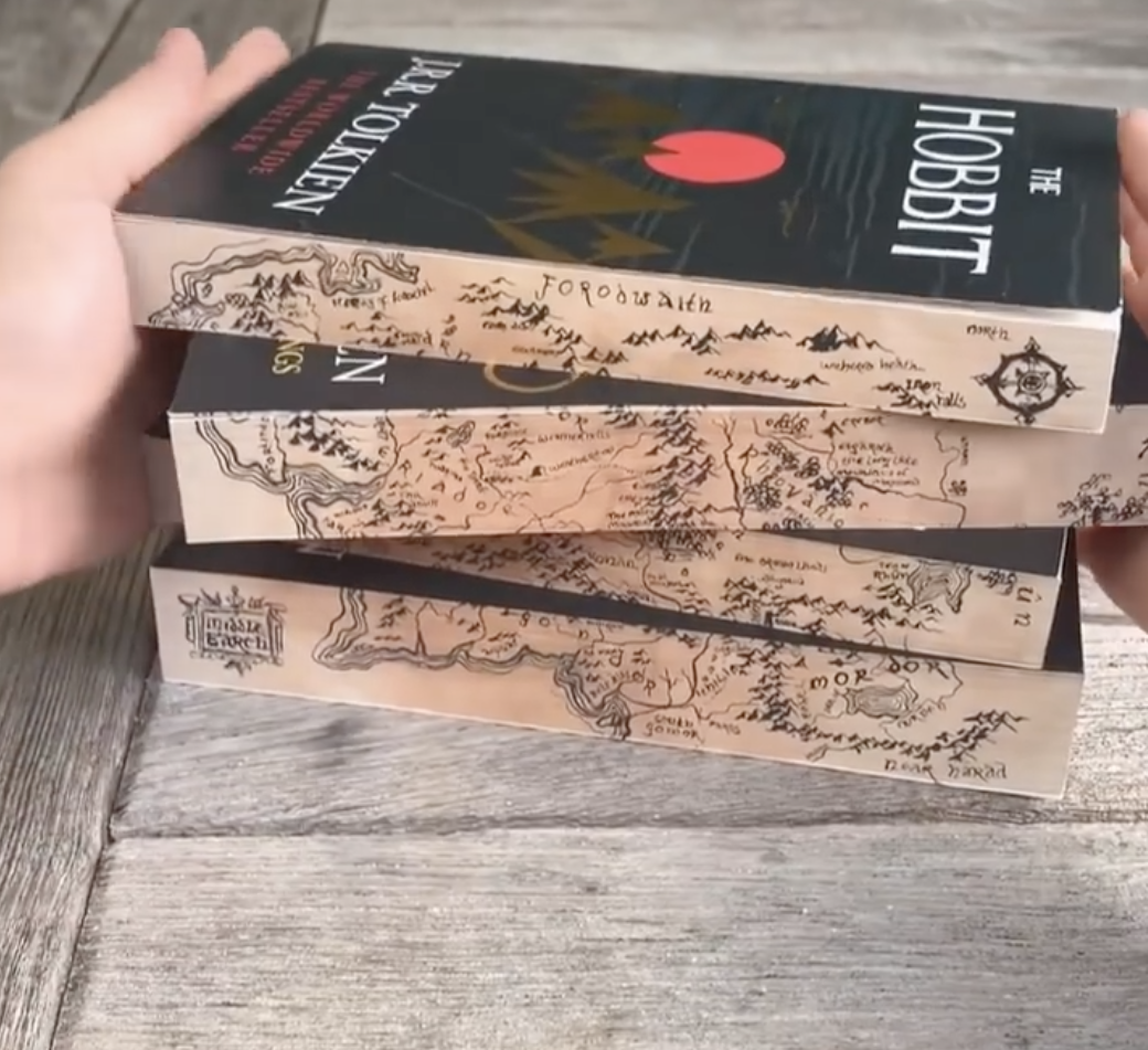 A stack of books that together create a complete map from the lord of the rings