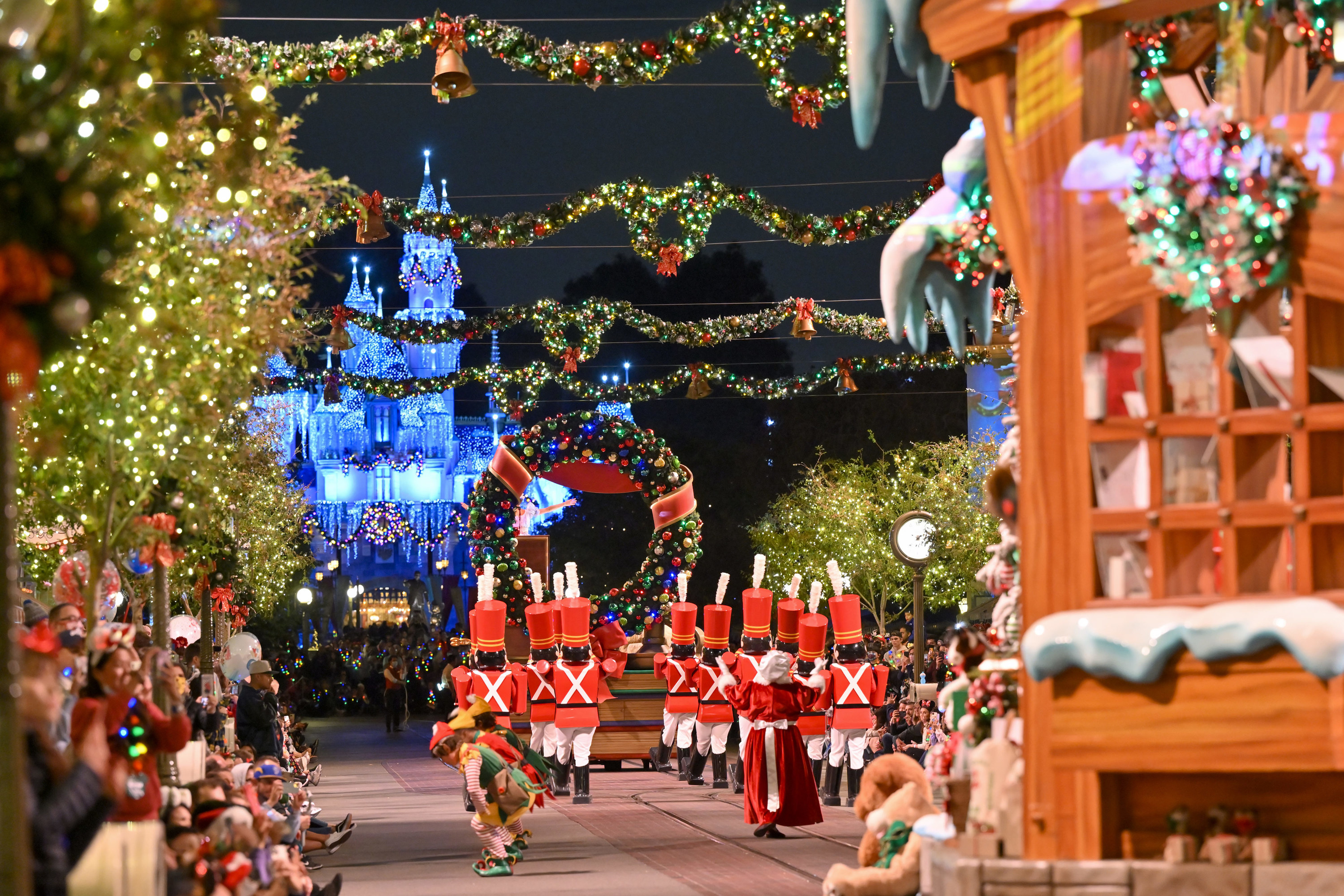 Christmas at Disney World with toy soldiers marching toward the lit-up castle, under garland and wreaths