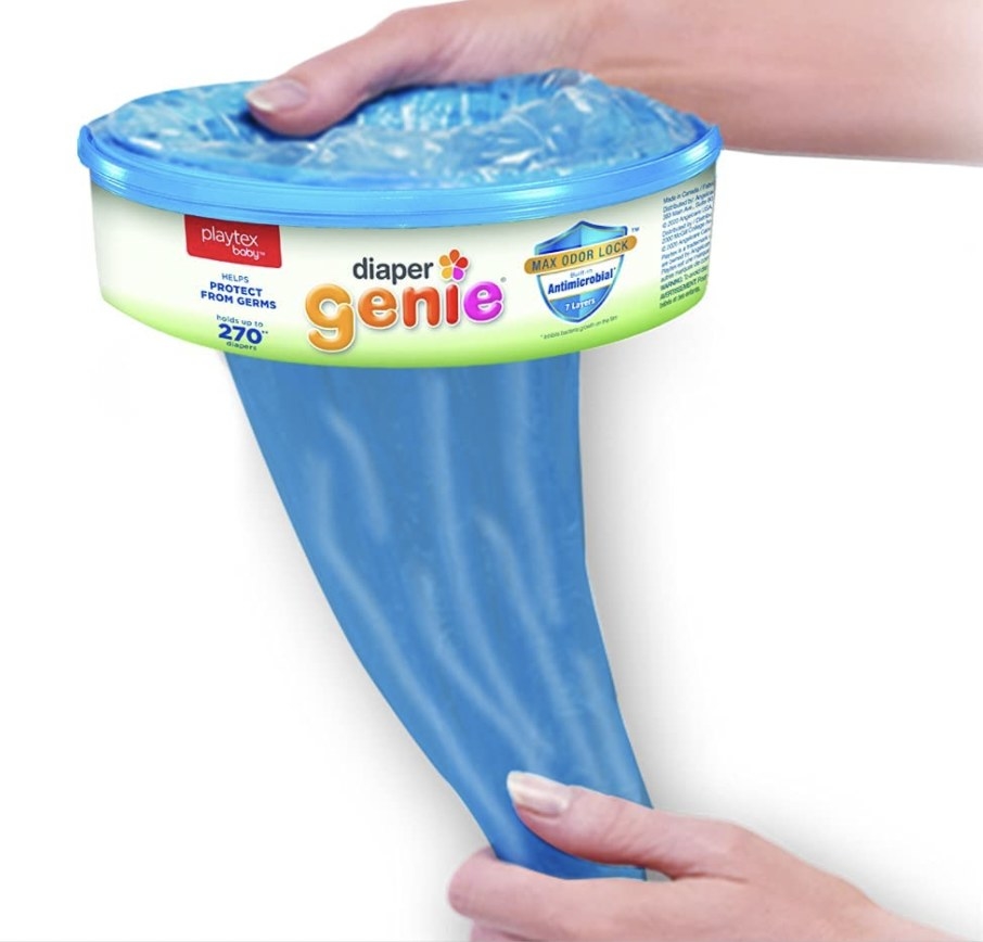 Hand pulling out diaper genie refill bag