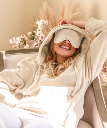 model in white hoodie with built-in sleep mask