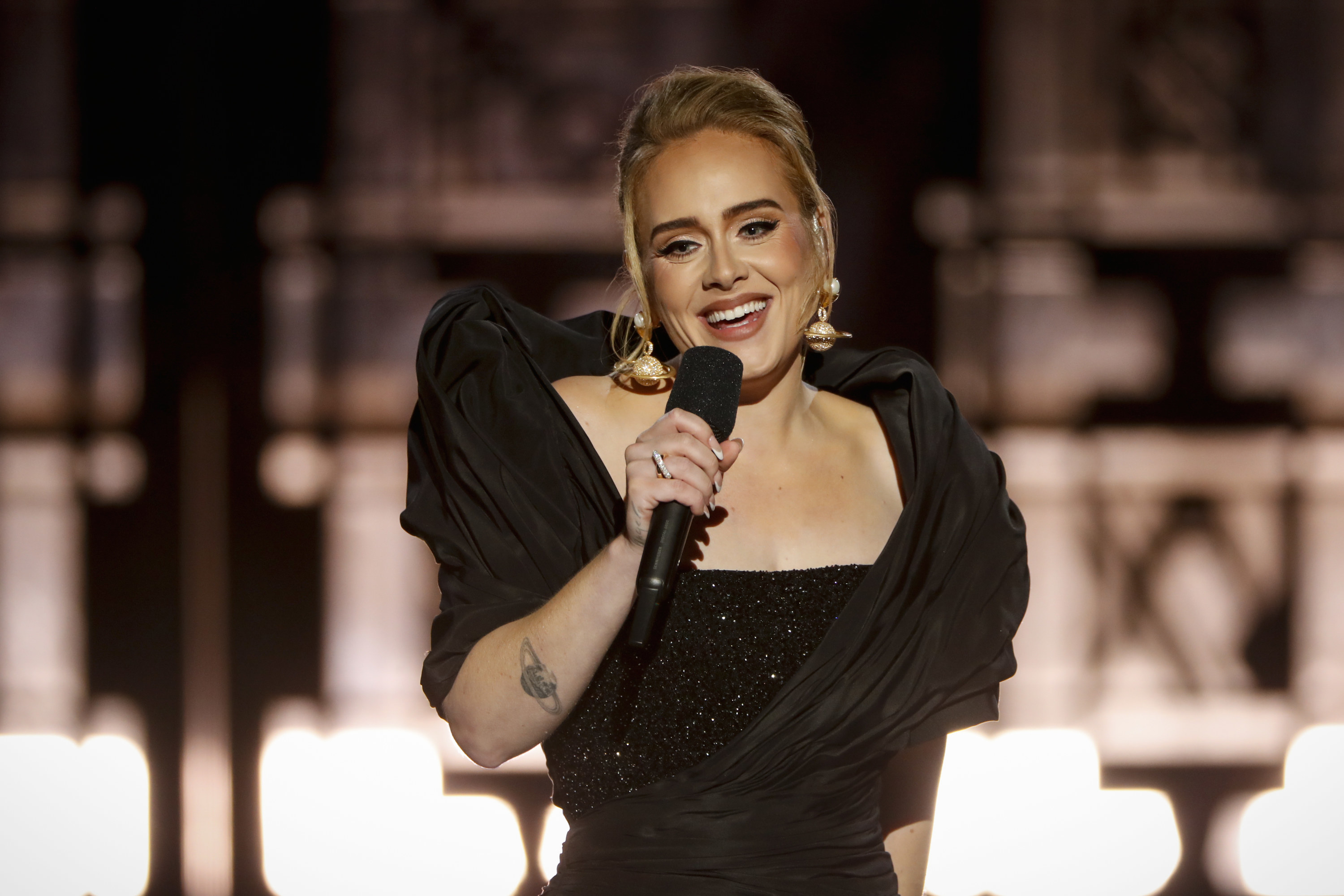 Adele looks out in the audience while holding a microphone