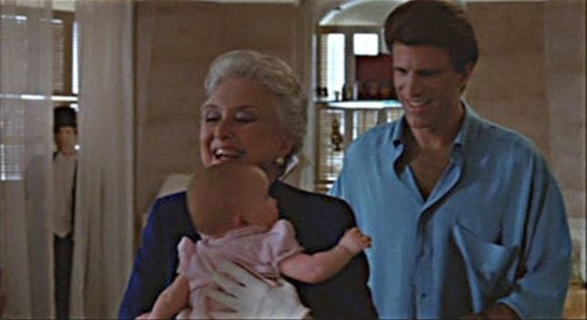 A cardboard cut of Ted Danson hides in the background of scene