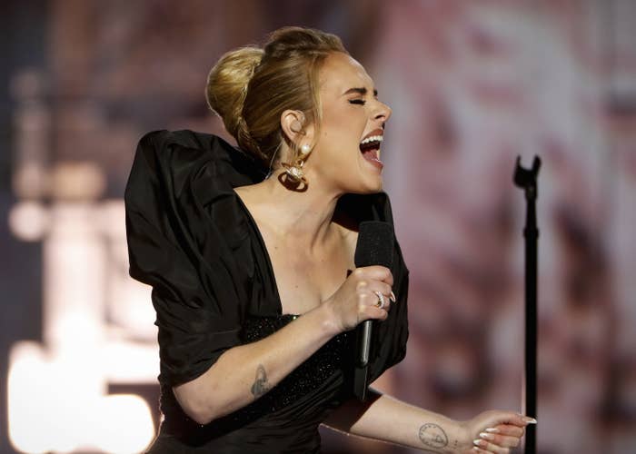 Adele sings while clutching a microphone