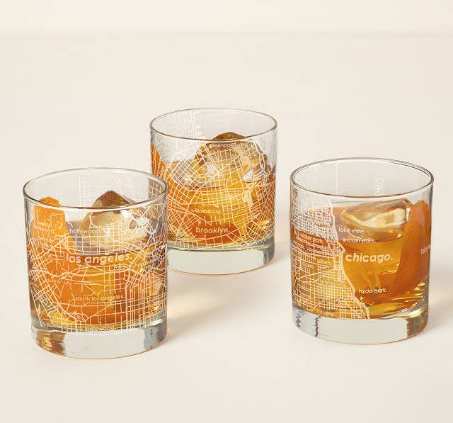 Three of the short glasses etched with LA, Chicago, and Brooklyn filled with bourbon