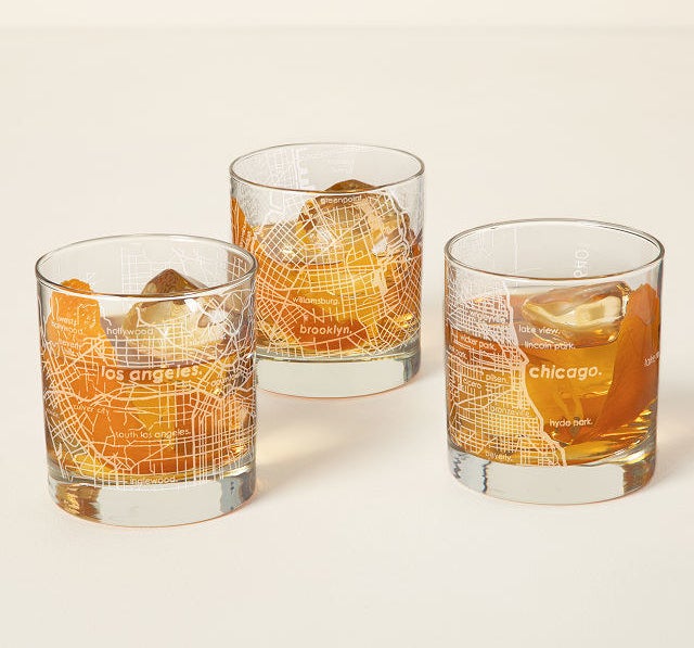 Three of the short glasses etched with LA, Chicago, and Brooklyn filled with bourbon