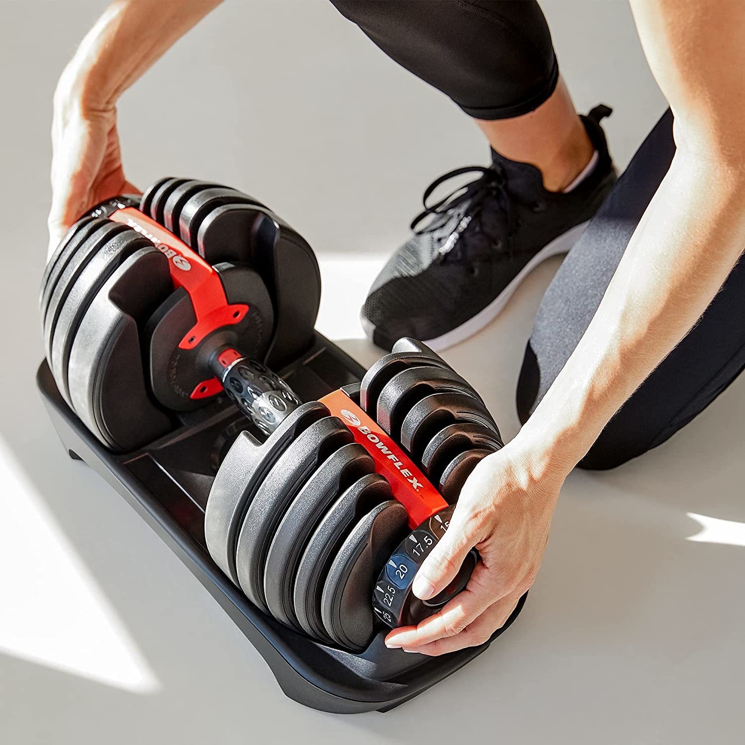 A person putting a dumbbell into its case