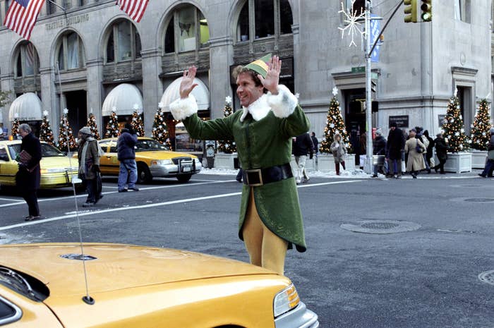 Buddy walking through the streets of New York in his elf outfit