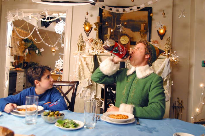 Buddy drinking cola from a massive bottle at the dinner table